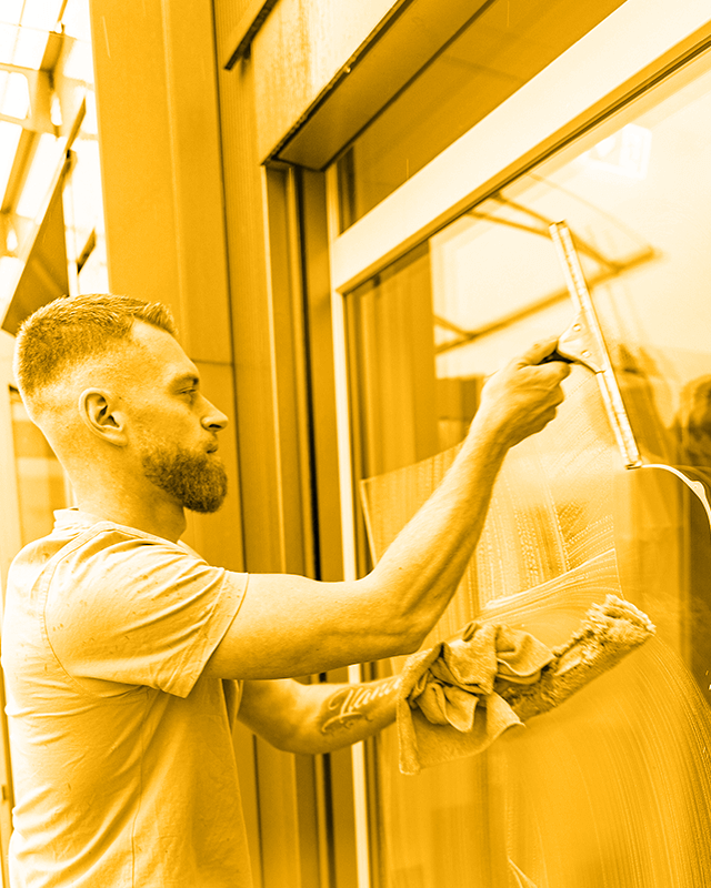 Wischbob Mitarbeiter führt Glasreinigung durch